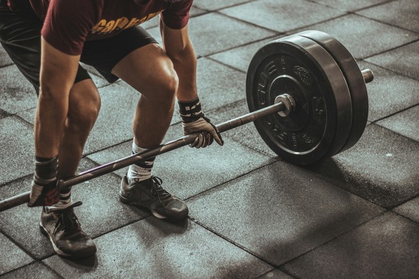 guy lifting a barbell in deadlift motion 